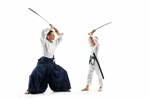 Hombre y adolescente peleando en el entrenamiento de Aikido en la escuela de artes marciales. Concepto de deporte y estilo de vida saludable.