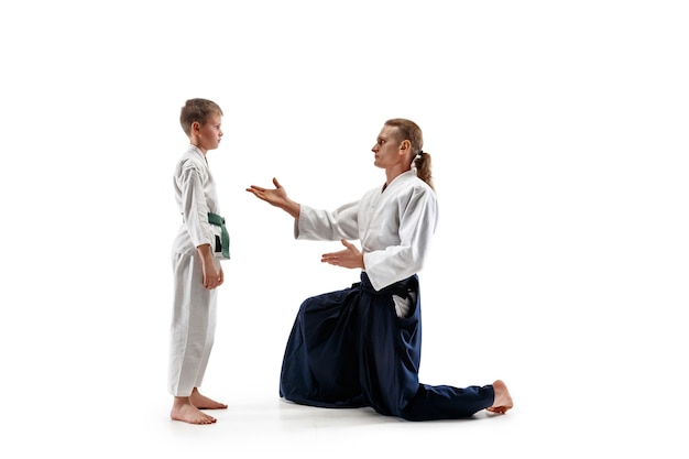 Hombre y adolescente peleando en el entrenamiento de Aikido en la escuela de artes marciales. Concepto de deporte y estilo de vida saludable.