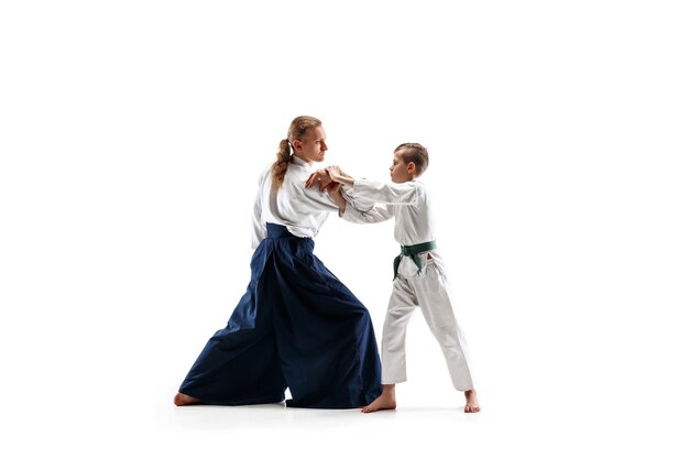 Hombre y adolescente peleando en el entrenamiento de aikido en la escuela de artes marciales