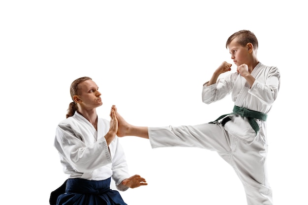 Hombre y adolescente peleando en el entrenamiento de aikido en la escuela de artes marciales