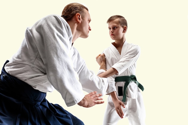 Hombre y adolescente peleando en el entrenamiento de Aikido en la escuela de artes marciales