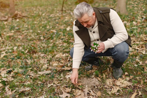 Hombre adulto elegante en un bosque de primavera