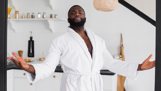 Hombre adulto guapo posando en bata de baño