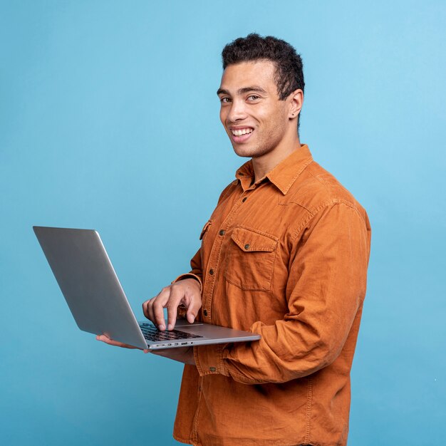 Hombre adulto guapo sosteniendo una laptop