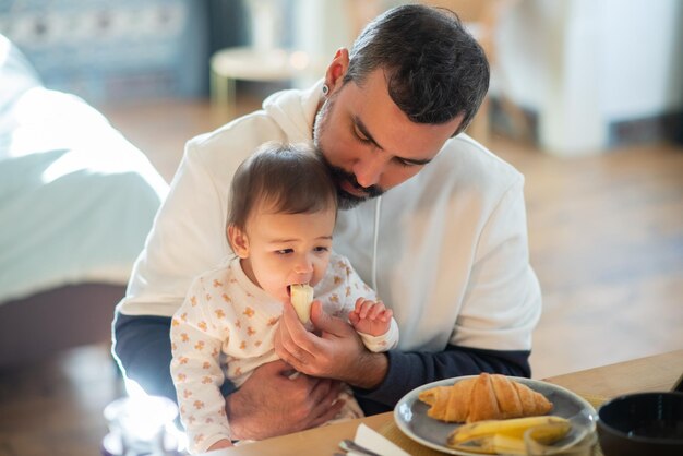 hombre adulto medio, alimentación, hijo bebé, con, plátano, en casa