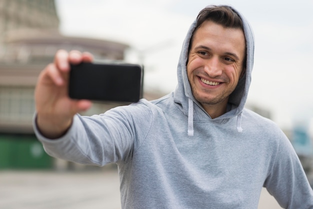 Foto gratuita hombre adulto positivo tomando una selfie