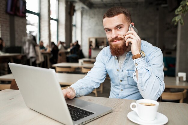 Hombre adulto que estudia la computadora portátil del negocio