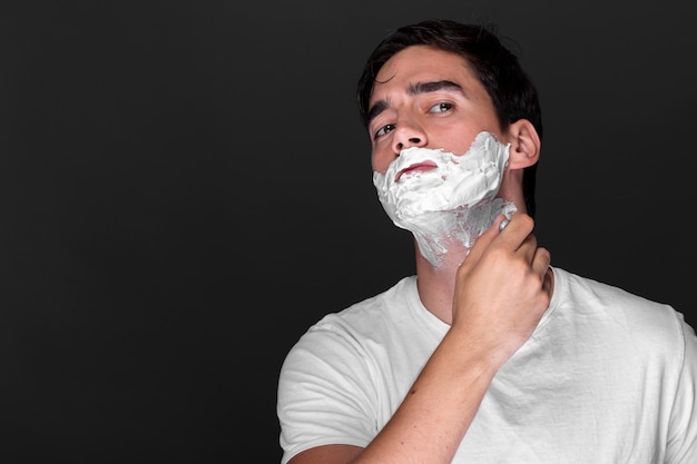 Hombre adulto seguro afeitándose la barba