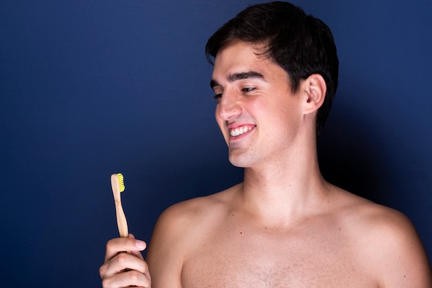 Hombre adulto sonriente con cepillo de dientes