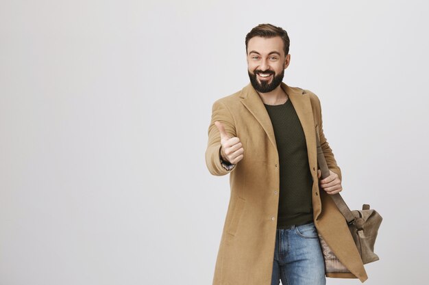 Hombre adulto sonriente muestra el pulgar hacia arriba en señal de aprobación