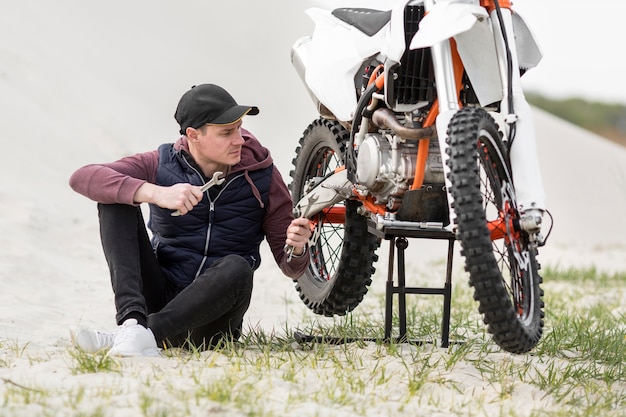 Hombre adulto tratando de reparar moto