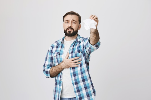 Hombre adulto triste agitando tejido diciendo adiós