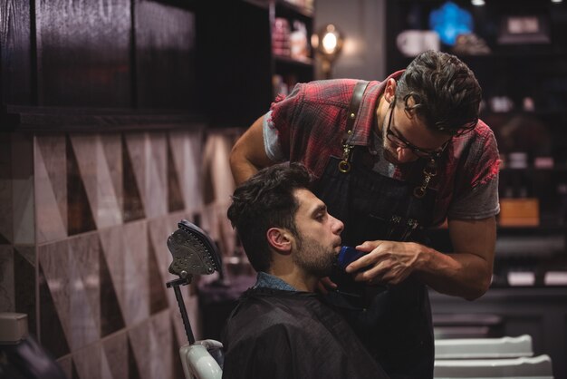 El hombre se afeita la barba con recortadora