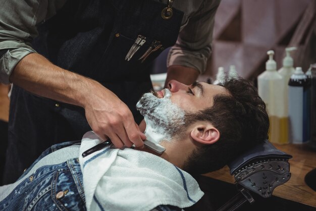 Hombre afeitado la barba con navaja