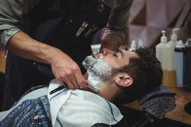 Hombre afeitado la barba con navaja