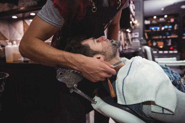 Hombre afeitado la barba con navaja