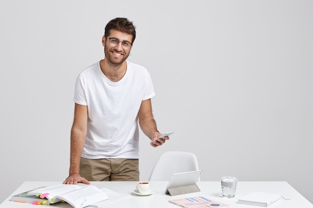 Foto gratuita hombre sin afeitar atractivo positivo trabaja en informe de noticias