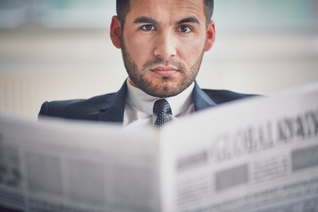 Hombre sin afeitar leyendo el periódico