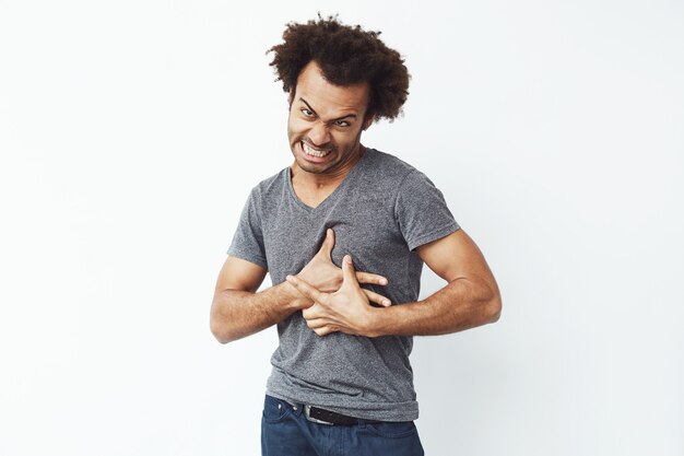 Hombre africano alegre haciendo cara divertida engañando.