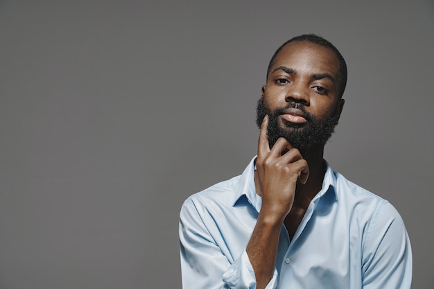 Foto gratuita hombre africano en un estudio. pared blanca. hombre con camisa azul.