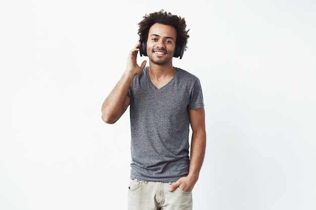 Hombre africano feliz en auriculares sonriendo