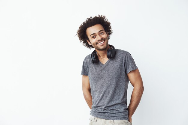 Hombre africano feliz con auriculares en su cuello escuchando música en streaming