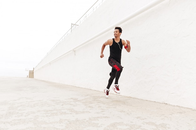 Foto gratuita hombre africano feliz deportes corriendo al aire libre.