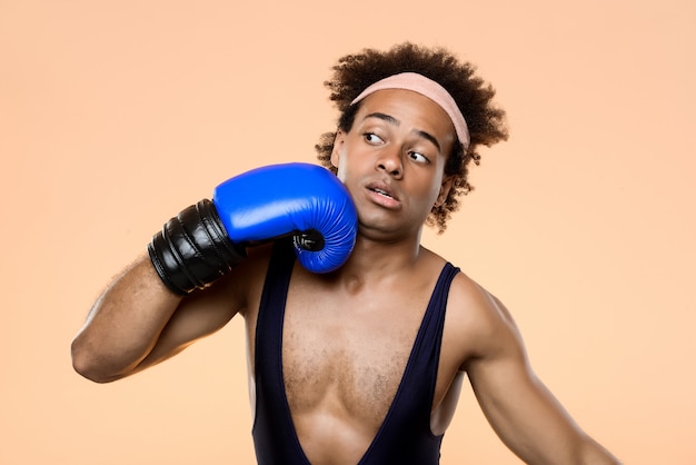 Foto gratuita hombre africano en guantes de boxeo golpeándose