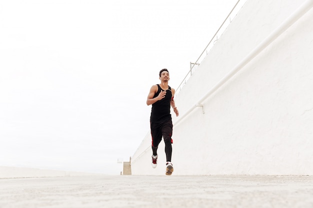 Hombre africano joven deportes corriendo al aire libre.