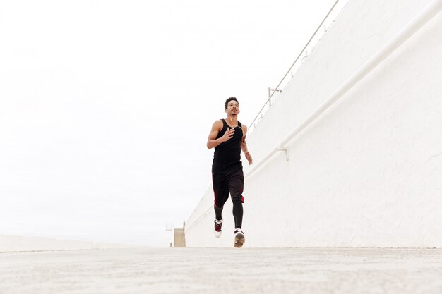 Hombre africano joven deportes corriendo al aire libre.