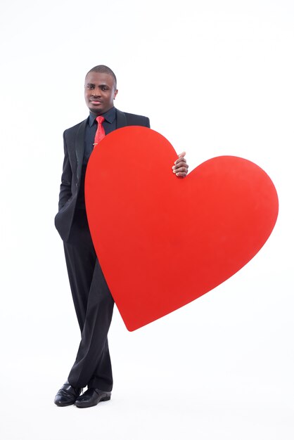 Hombre africano serio y guapo con gran corazón rojo