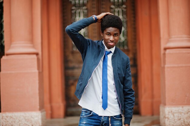 Hombre africano vestido con corbata y ropa informal posando al aire libre