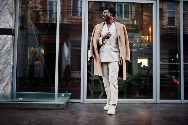 Hombre afro con estilo en traje y abrigo beige de la vieja escuela