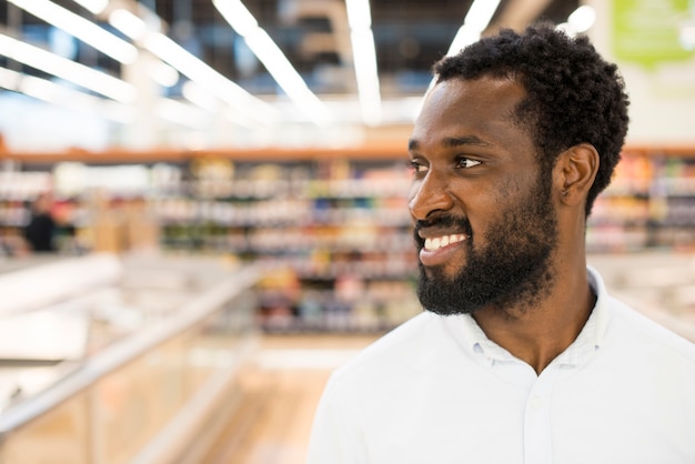 Hombre afroamericano alegre en la tienda de comestibles