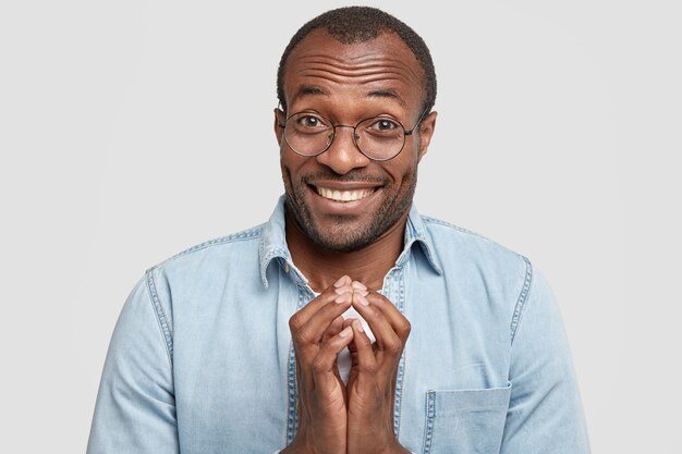 Hombre afroamericano con anteojos redondos y camisa vaquera