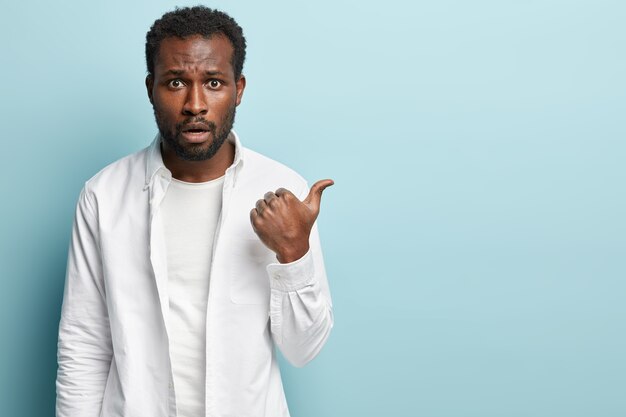 Hombre afroamericano con camisa blanca posando