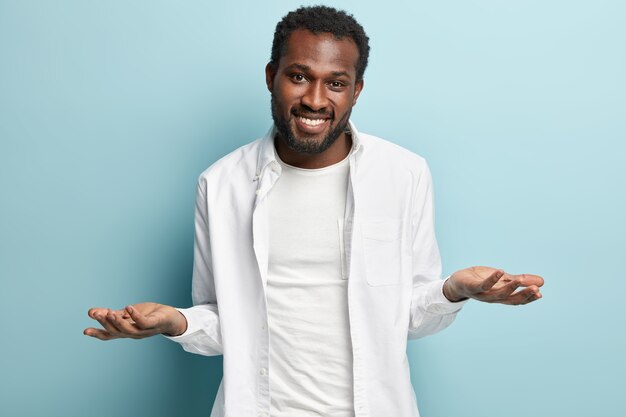 Hombre afroamericano con camisa blanca posando