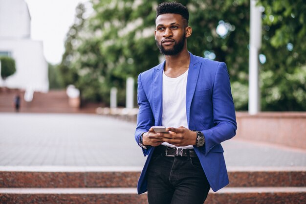 Hombre afroamericano en chaqueta azul usando teléfono