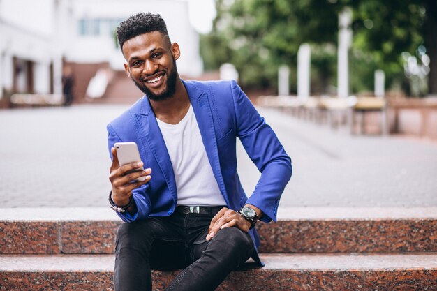 Hombre afroamericano en chaqueta azul usando teléfono