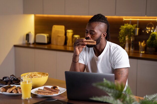 Hombre afroamericano comiendo tarde en la noche