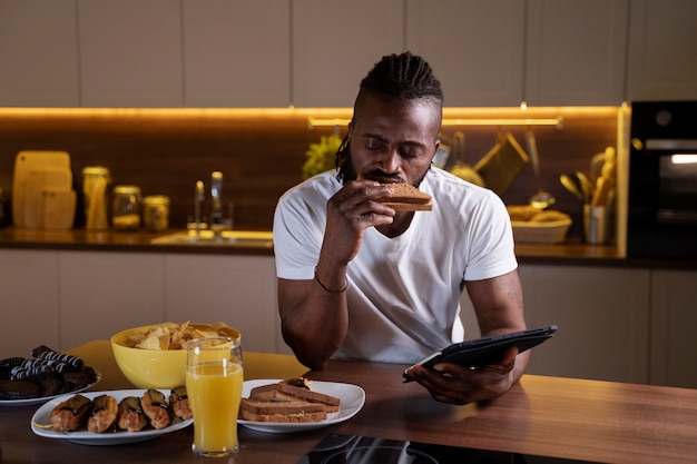 Hombre afroamericano comiendo tarde en la noche