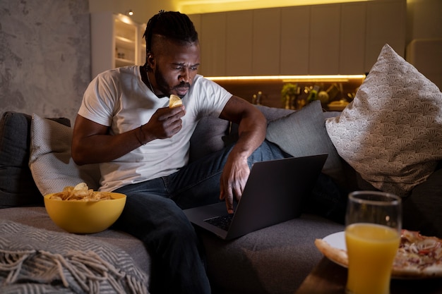 Foto gratuita hombre afroamericano comiendo tarde en la noche