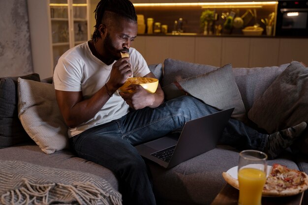 Hombre afroamericano comiendo tarde en la noche