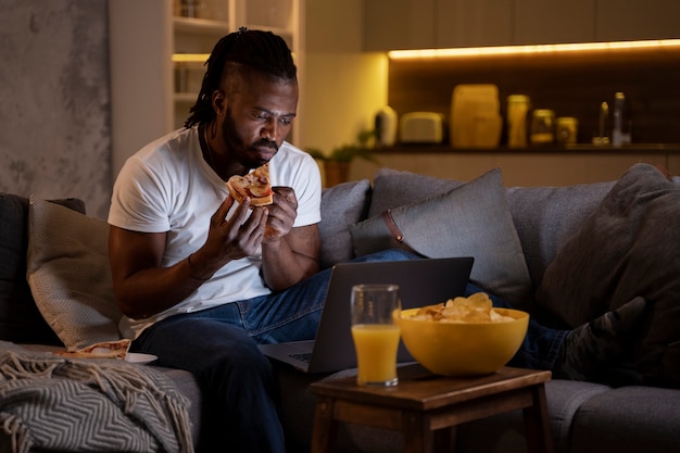 Hombre afroamericano comiendo tarde en la noche