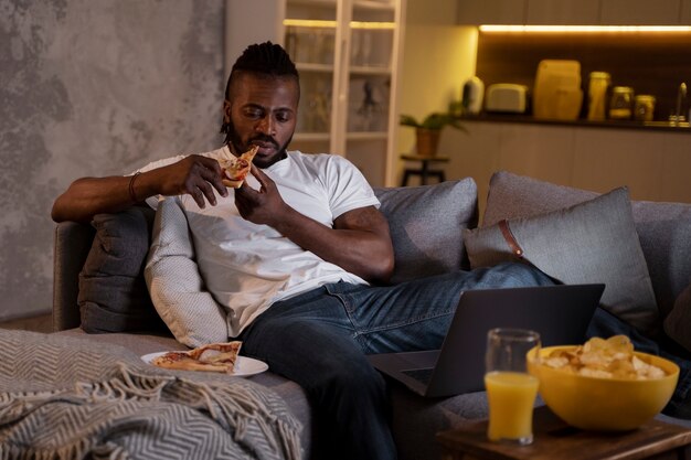 Hombre afroamericano comiendo tarde en la noche