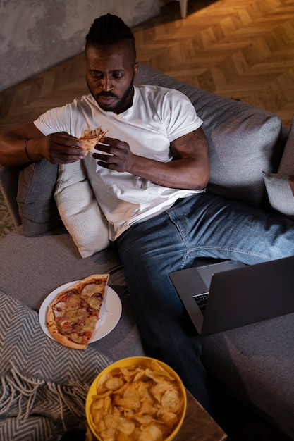 Hombre afroamericano comiendo tarde en la noche