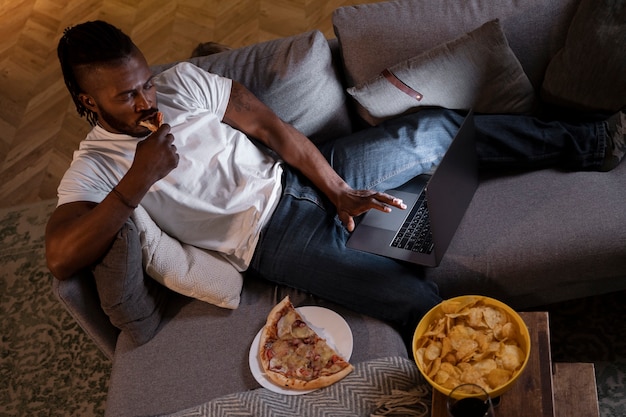 Hombre afroamericano comiendo tarde en la noche