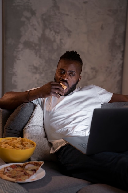 Foto gratuita hombre afroamericano comiendo tarde en la noche