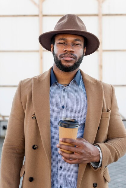 Hombre afroamericano elegante sosteniendo una taza de café