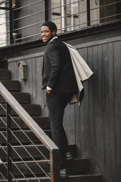 Hombre afroamericano en un elegante traje negro.